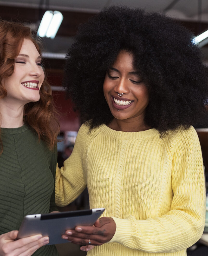 Two women laughing over ipad