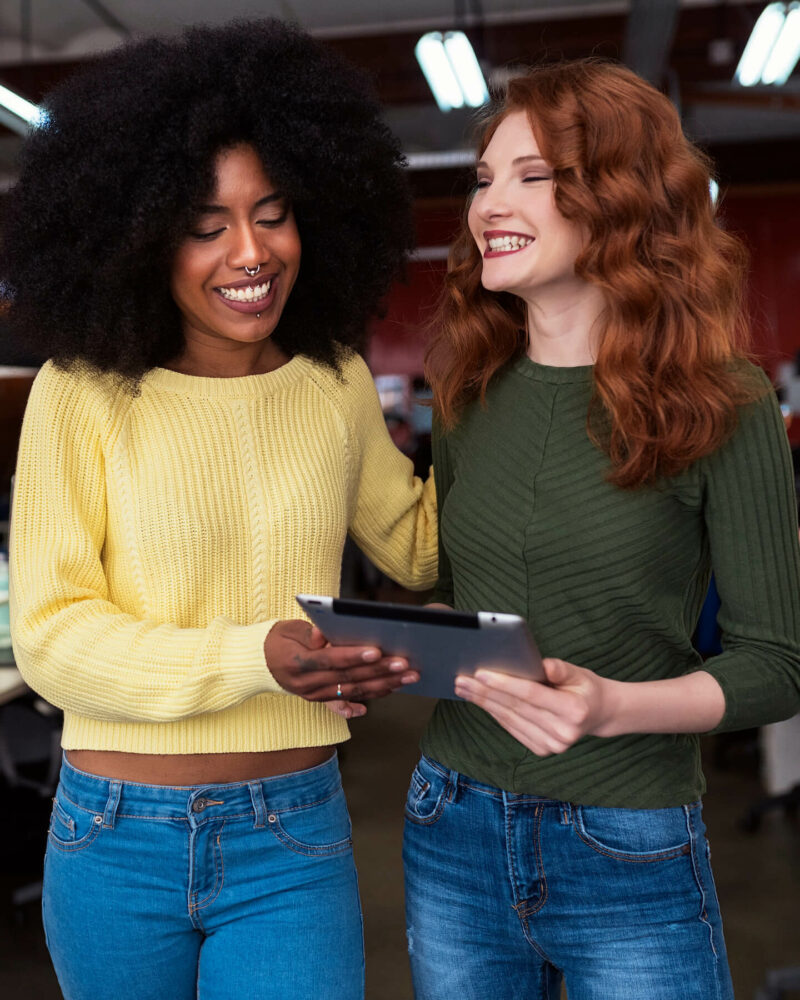 Women smiling over ipad vertical